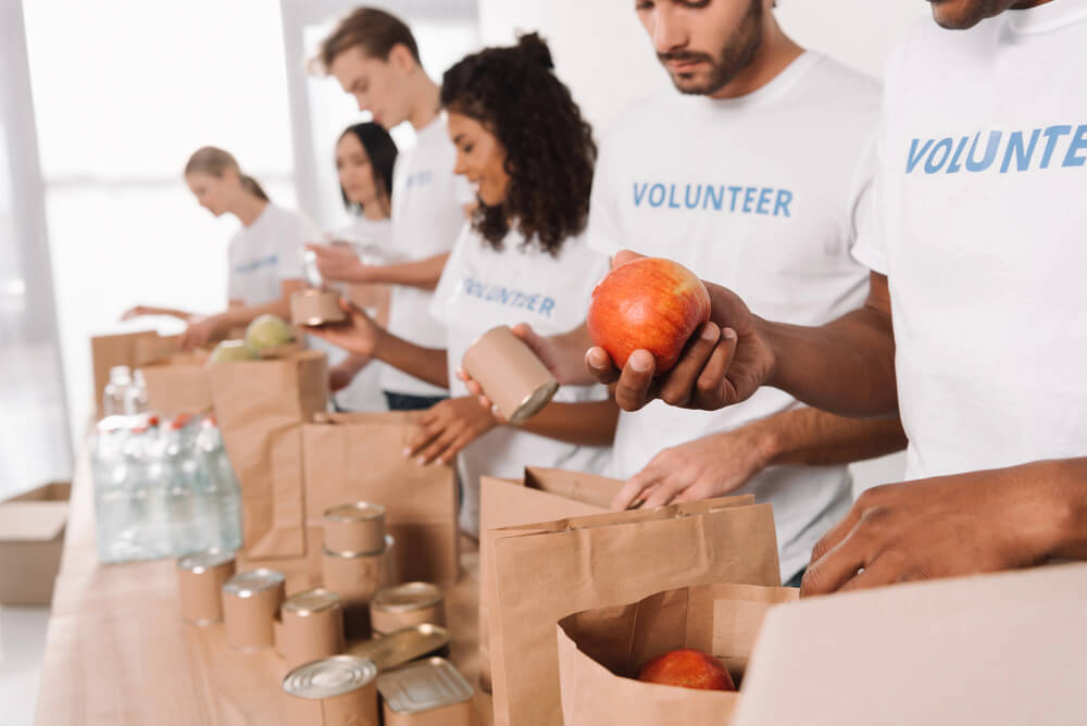 Volunteers putting food into paper bags