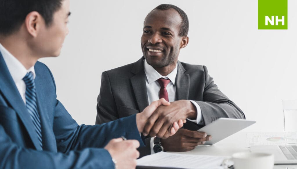 Two professionals shake hands, representing a business and nonprofit partnership