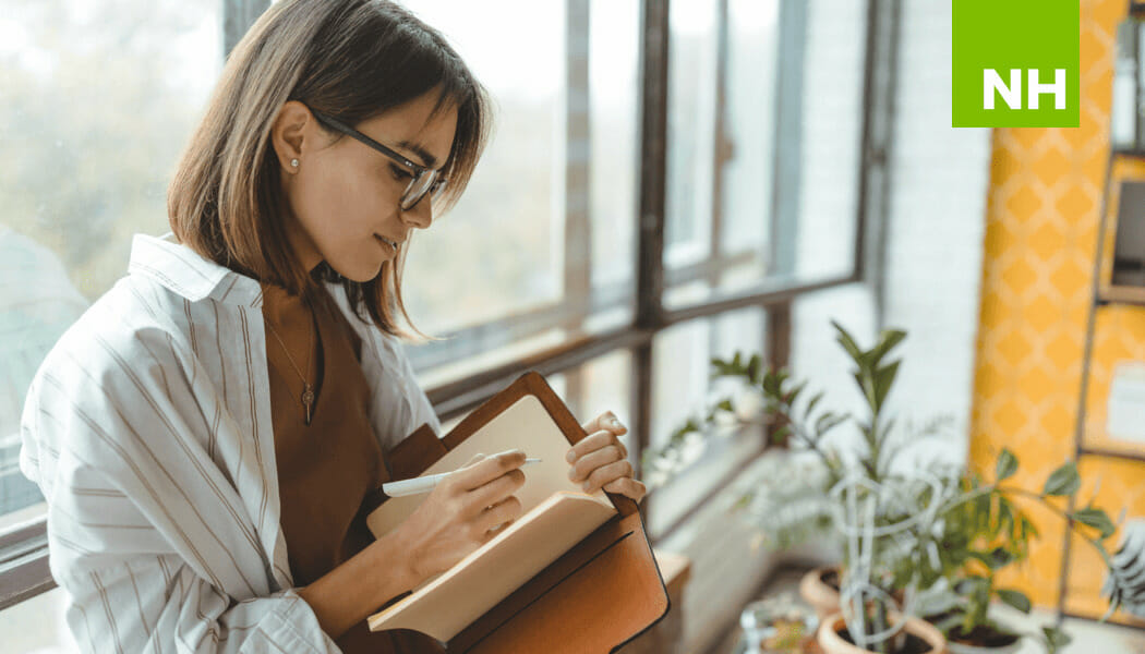 Woman smiling and writing in a journal