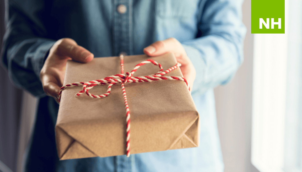 Person holding a gift tied with ribbon